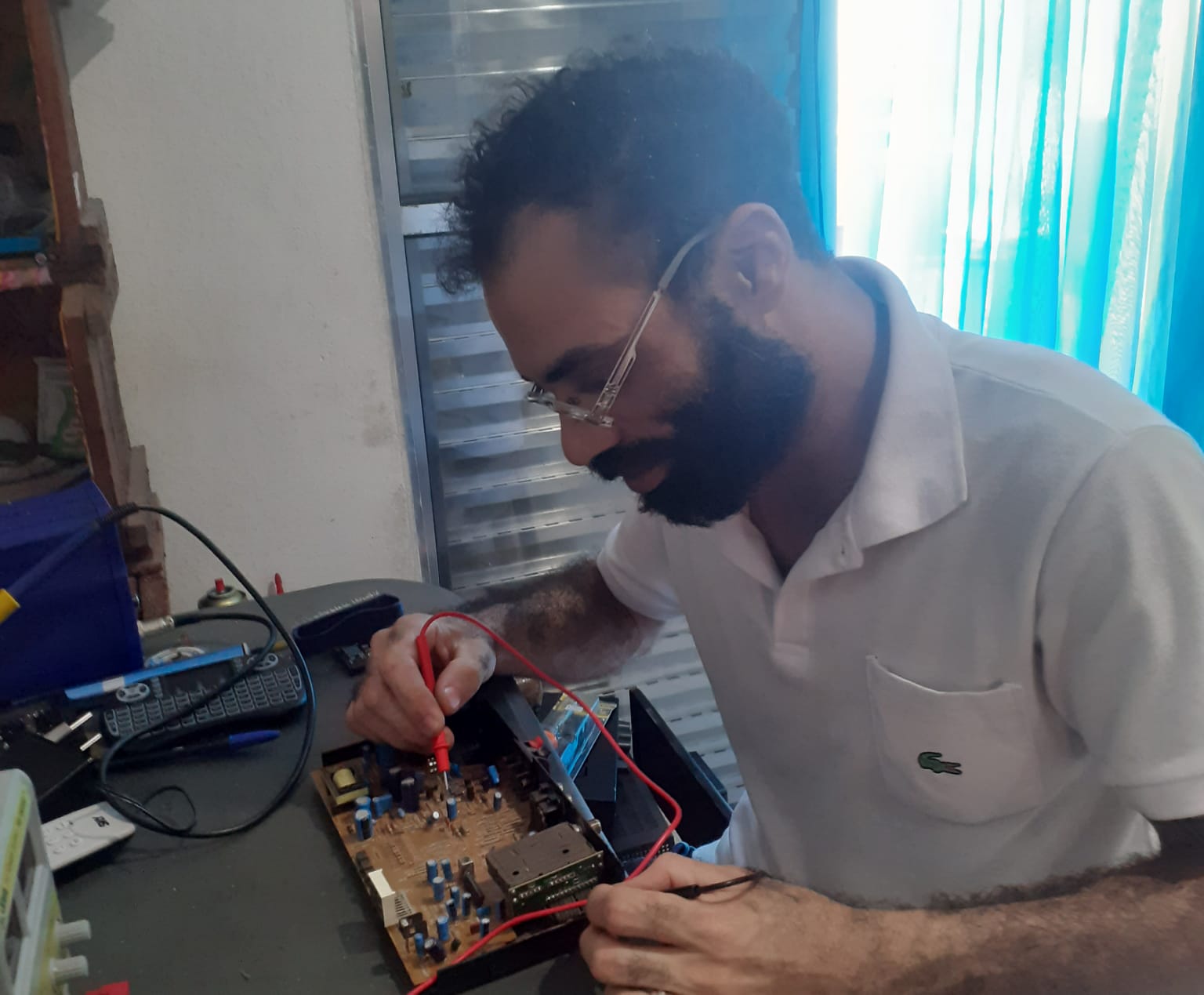 Ricardo Marques consertando componente eletrônico